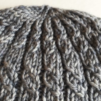 a detail of top of Stormy Harbour Hat by Imagined Landscapes Designs, Sweet Georgia Yarn