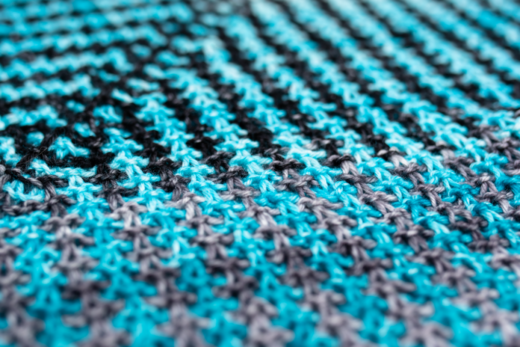 strong textured stitches of blue, black and grey move in a strong diagonal